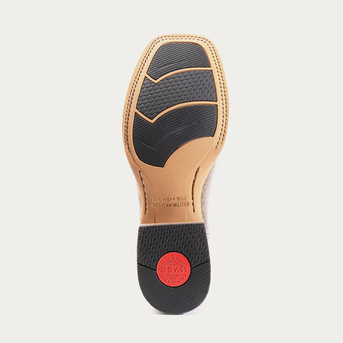 Shoe sole with black rubber outsole and tan leather uppers on a light gray background