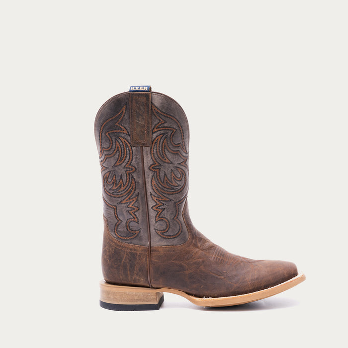 Brown cowboy boot with tan and black intricate stitching on a light gray background