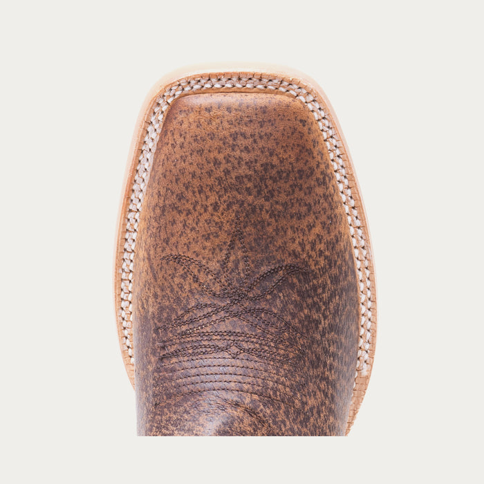 Toe of brown cowboy boot with tonal stitching on a light gray background