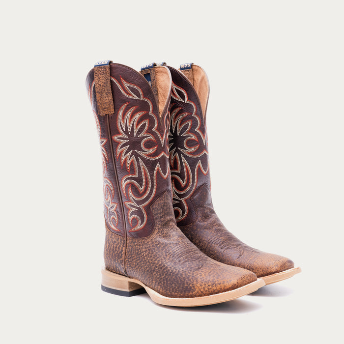 Pair of brown cowboy boots with white and red intricate stitching on a light gray background