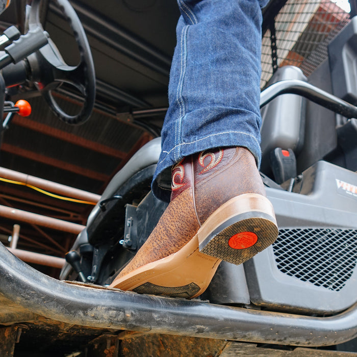 Person wearing brown cowboy boots with red heel cap stepping  inside a vehicle.