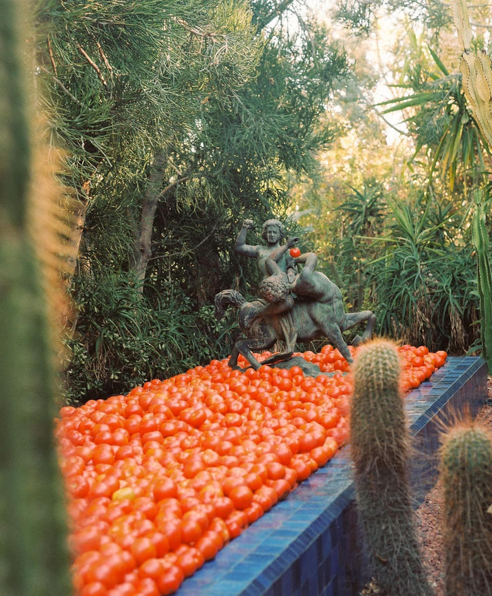 A bronze statue of a human and centaur holds a tomato.