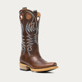 Brown cowboy boot with intricate white and blue embroidery on a light gray background