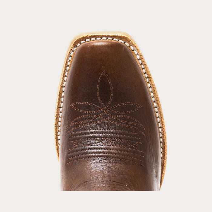 Close-up of a brown leather boot with intricate stitching on a light gray background