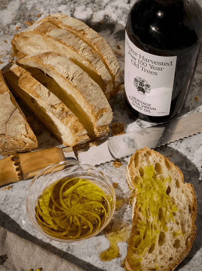 Extra Virgin Olive Oil and bread on a marble table