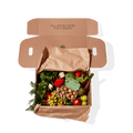 Box containing fresh produce and eggs placed on brown paper.