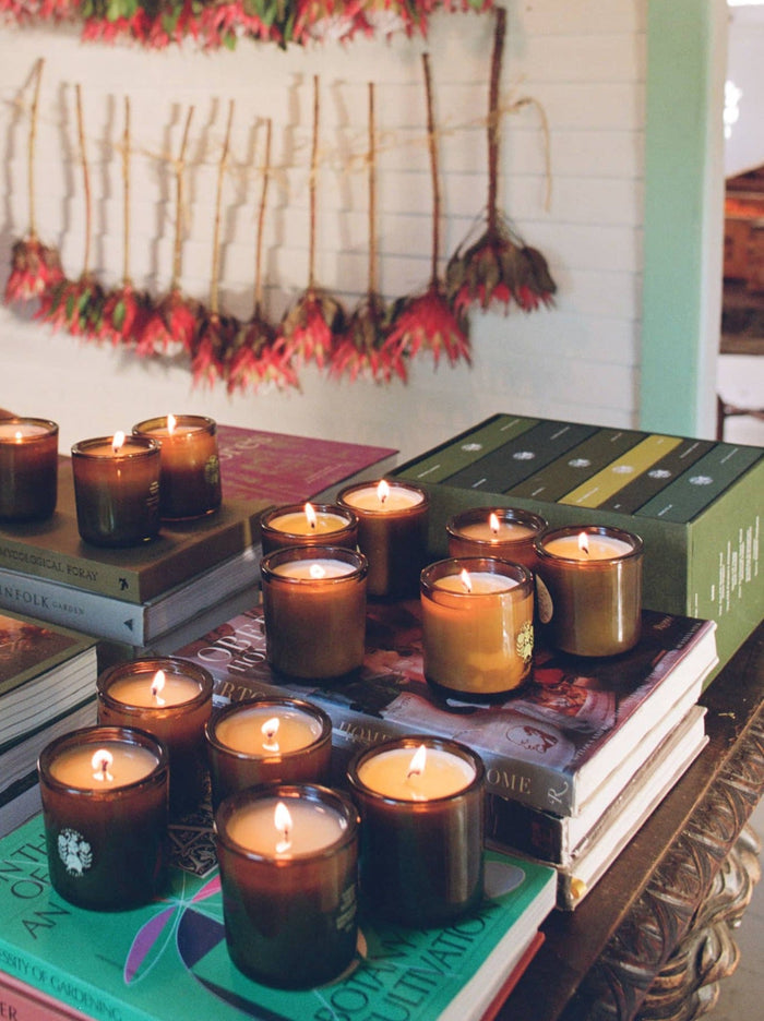 Candles glow atop stacked books, creating a warm ambiance.